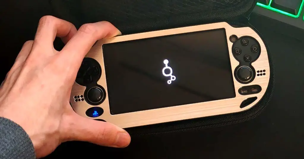 Classic PlayStation Vita handheld console in a silver case, with custom firmware installed.