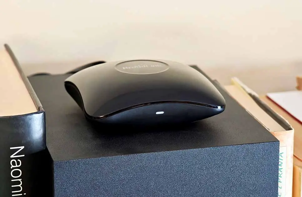 Broadlink RM4 Pro IR/RF blaster placed on a shelf with the front status LED visible.