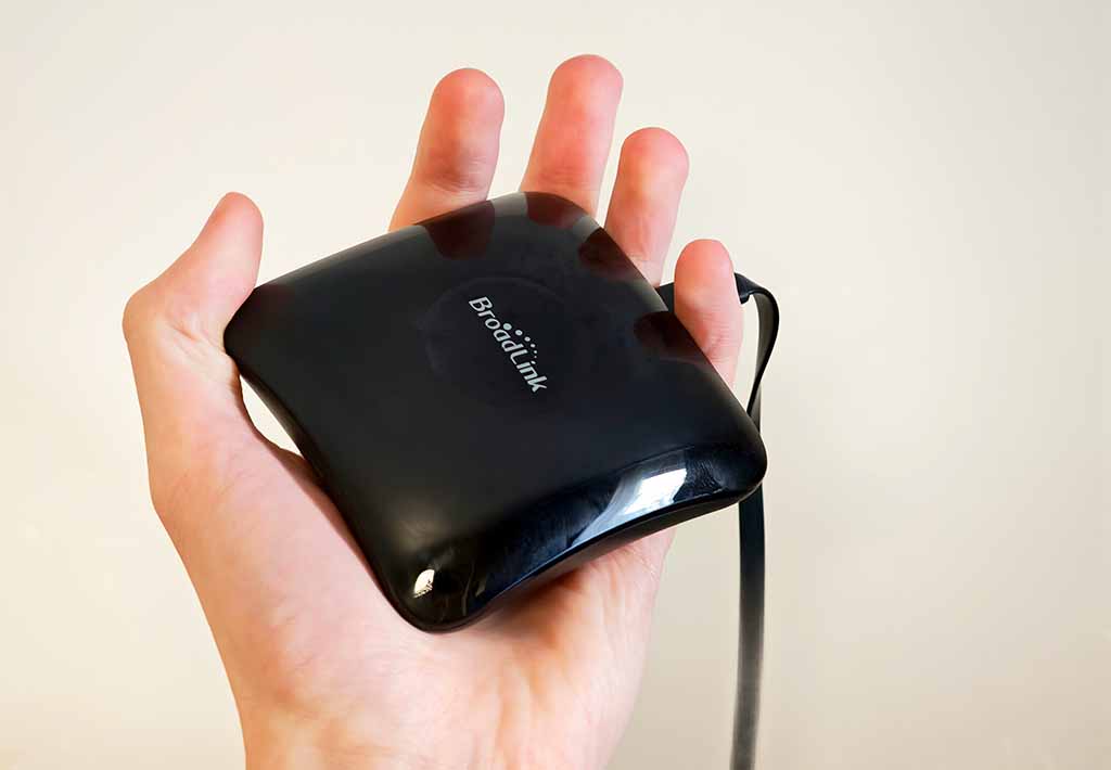 Broadlink RM4 Pro IR and RF bridge resting in a hand to show its size.