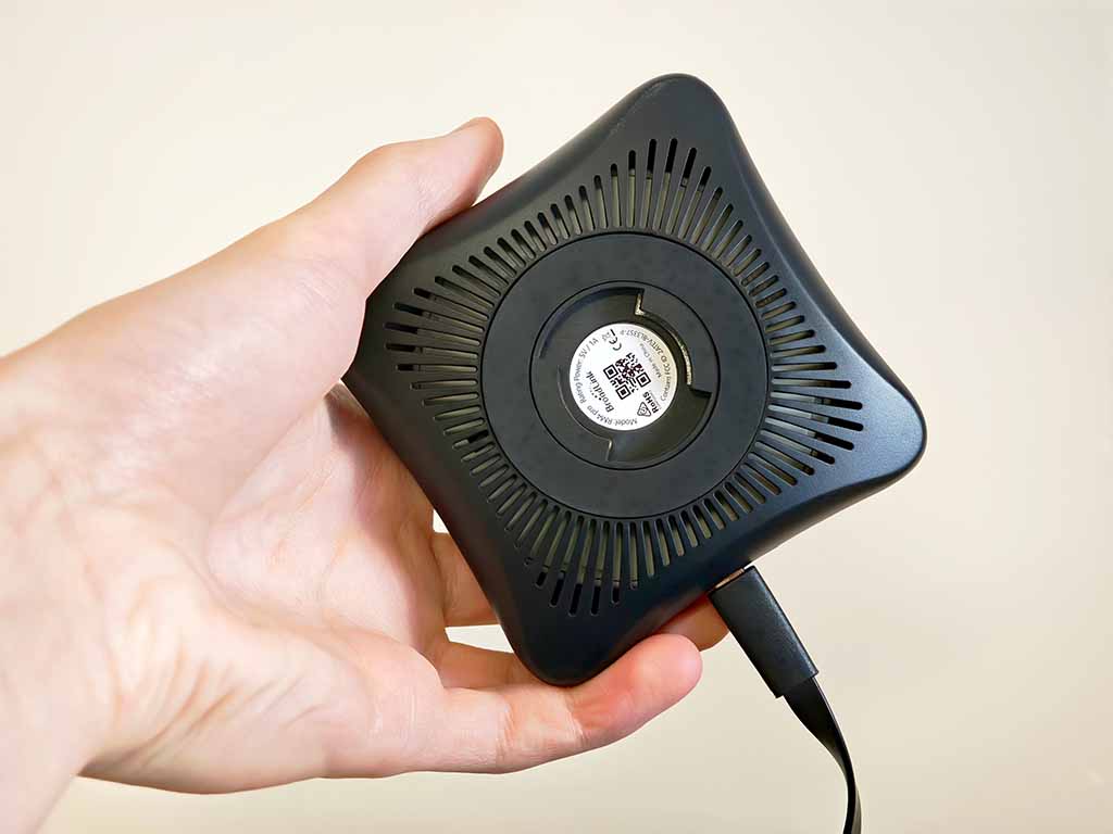 Bottom view of a Broadlink RM4 Pro: rubber base and a Micro-USB power cable connected.