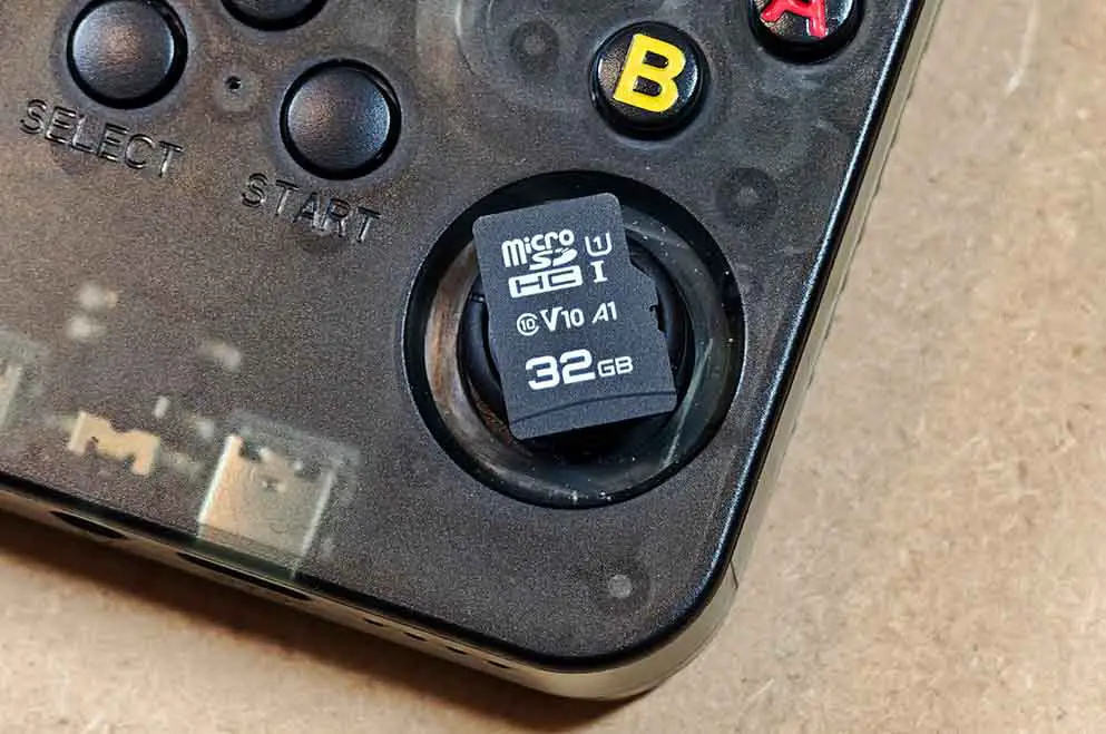 Close-up of a generic 32GB microSD card resting on the front of the R36S.