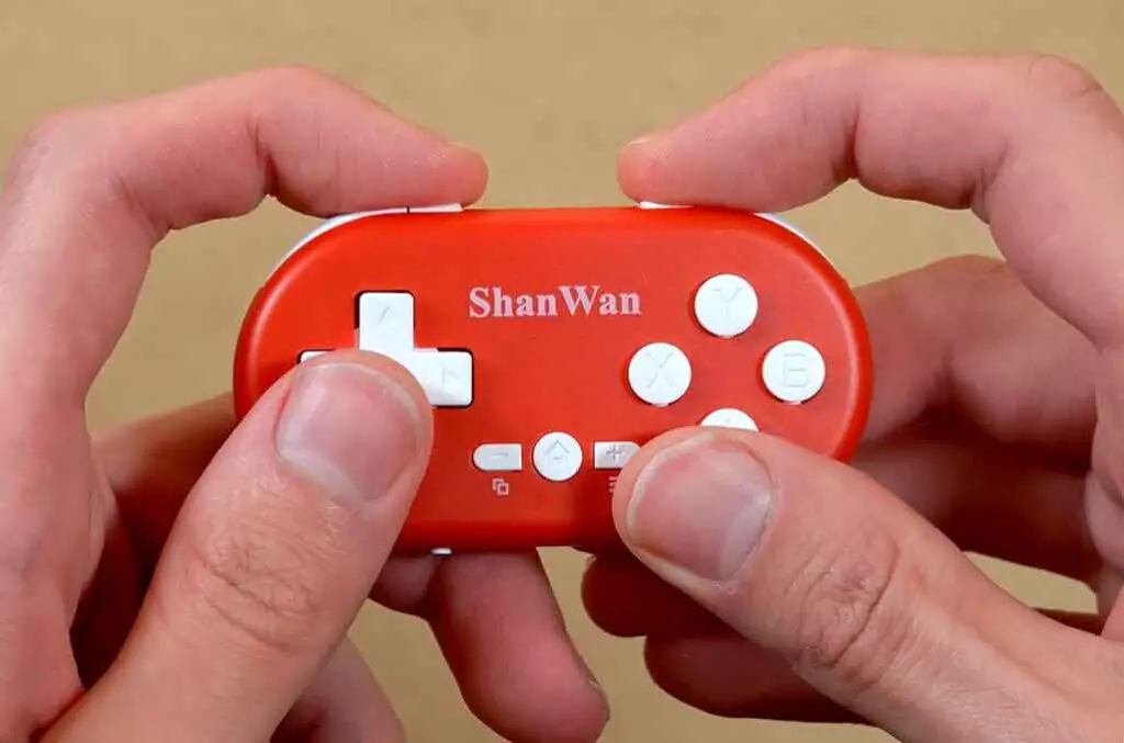 ShanWan Q36 held in both hands while pressing the buttons.