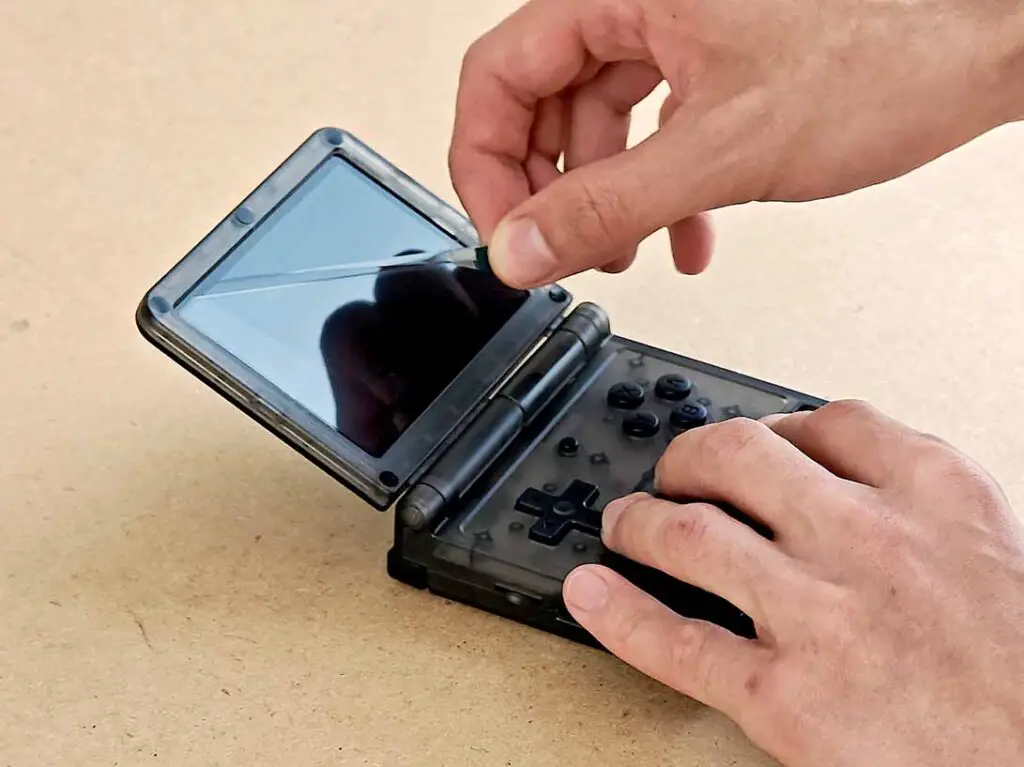 Peeling off the foil from the Powkiddy V90S display.