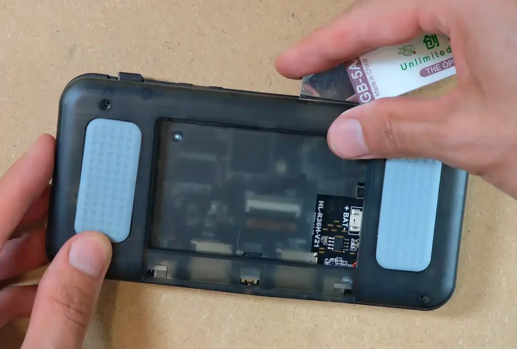 Lifting the rear plastic shell away from the R36H handheld body using a pry tool.