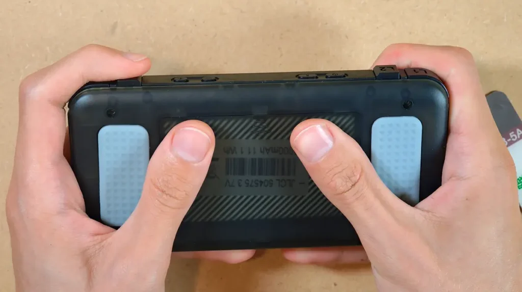 R36H handheld with the rear battery cover being slid open by hand.