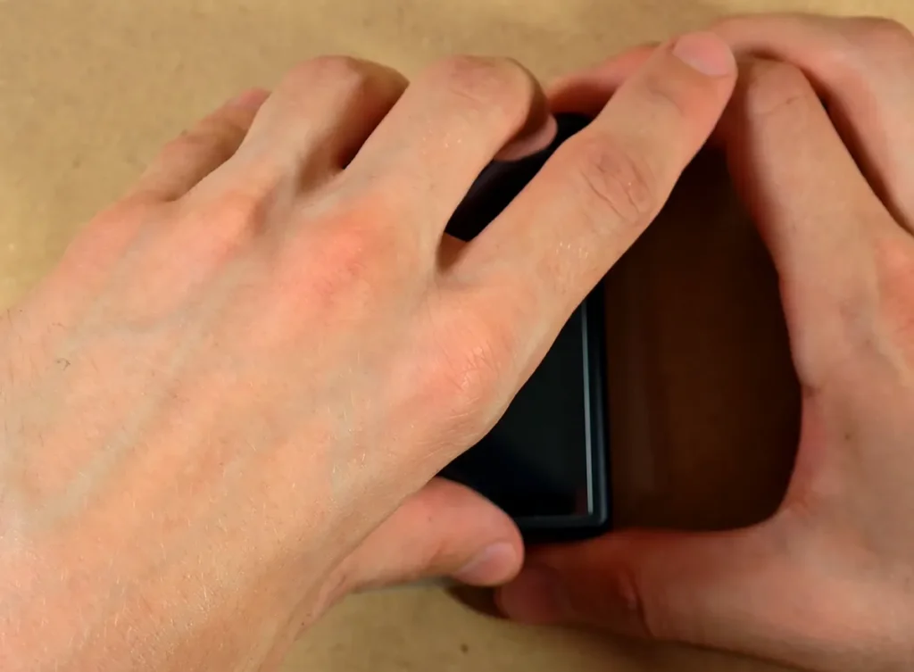 Applying the included screen protector to the Anbernic RG Rotate.