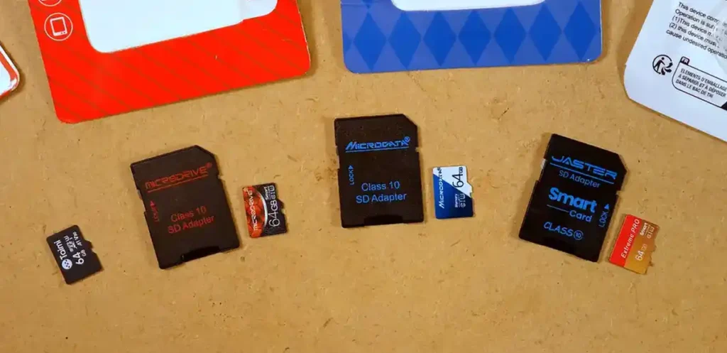 Four AliExpress 64GB microSD cards and three included SD adapters prepared for testing.