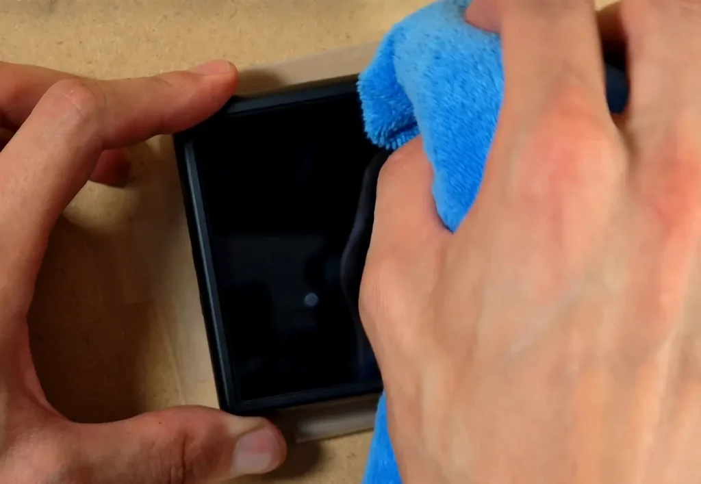 Removing the remaining bubbles from the RG Rotate screen protector using a cloth.