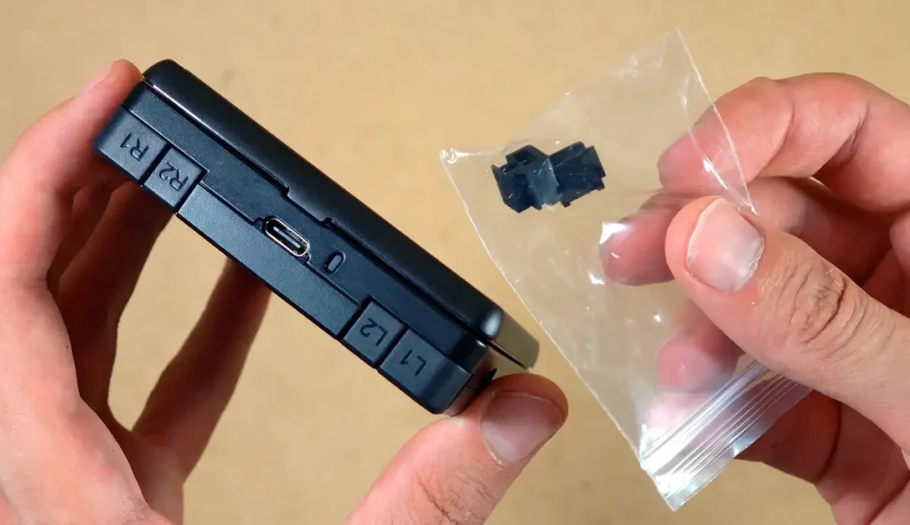 The back of the RG Rotate with the included taller replacement shoulder buttons in a small bag.