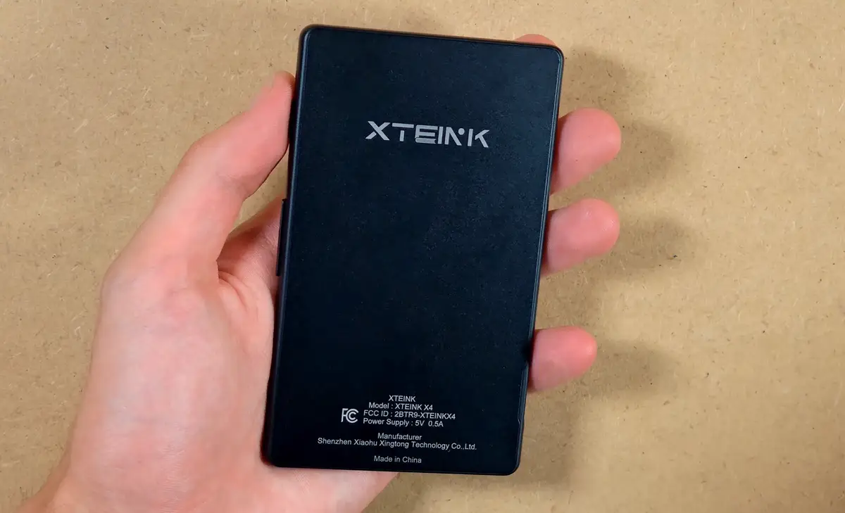 Back of the Xteink X4 with branding regulatory text and flat magnetic surface.