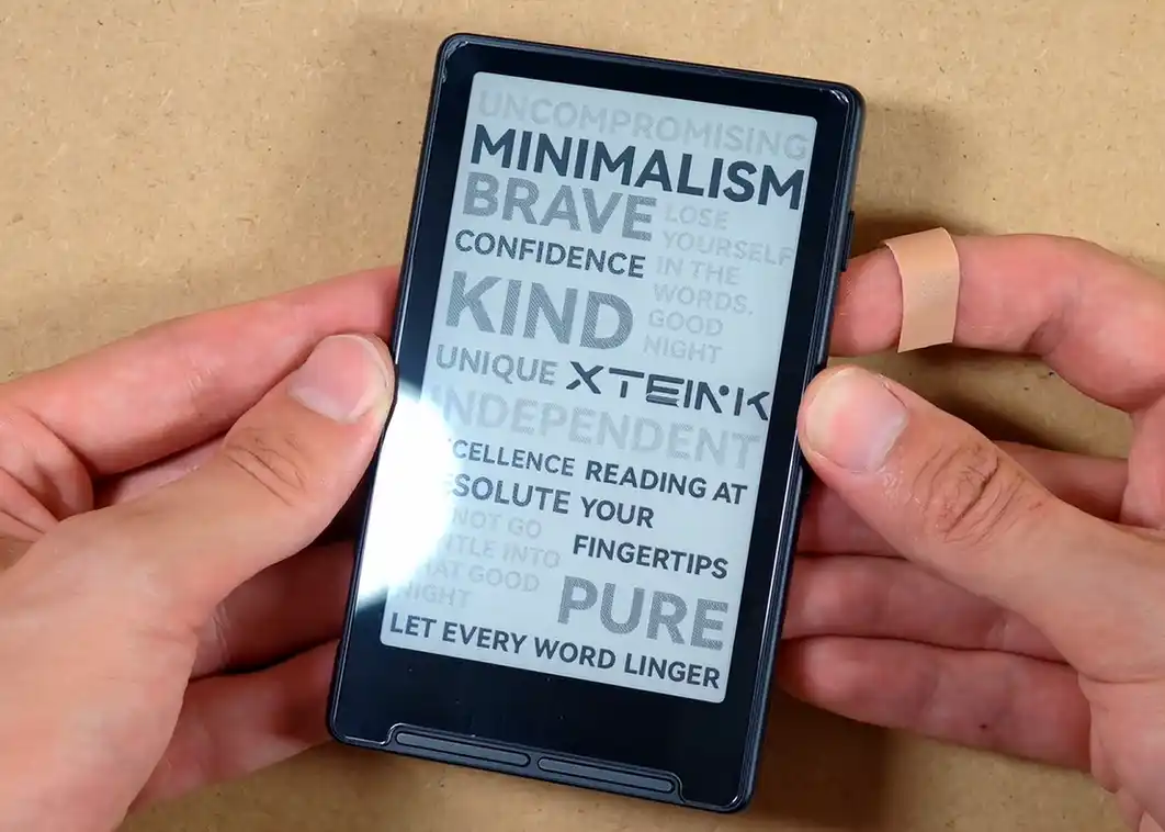 Xteink X4 with tempered glass screen protector showing a strong reflection.