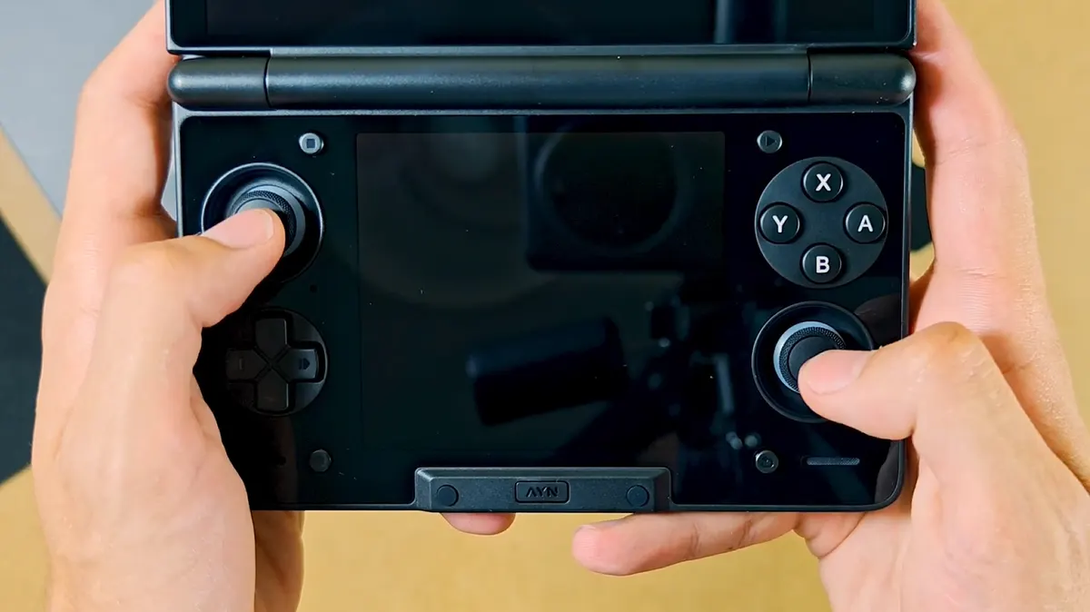 The natural grip on the bare AYN Thor held with both thumbs resting on the controls.